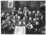 Children in a Gordonia Zionist youth group pose around a photograph of A.D.