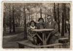 A Polish Jewish family sits around a picnic table in the woods near Lodz the summer before the start of World War II.