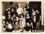 A group Polish Jewish girls, many of whom are wearing costumes, attend the 10th birthday party of Inka Gerson.