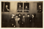 A group of women pose outside a train in the Budapest station.