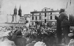 Mordechai Chaim Rumkowski, chairman of the Lodz ghetto Jewish Council, delivers a speech to a crowd of Jews gathered in a public square on Lutomierska Street in the Lodz ghetto.