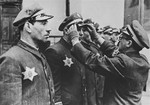 Symche Spira, the senior officer of the Krakow ghetto police (Ordnungsdienst) straightens the cap of one of his men during roll call.