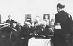 Jewish council chairman Mordechai Chaim Rumkowski (center), views a presentation album at a ceremony in the Lodz ghetto.