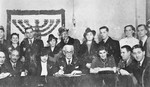 Jewish council chairman Mordechai Chaim Rumkowksi (seated in the center), poses with members of the council and four couples at a joint wedding celebration in the Lodz ghetto.