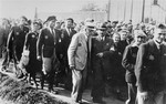 Mordechai Chaim Rumkowski, chairman of the Jewish Council (center), leaves the site of a public demonstration in the Lodz ghetto after delivering a speech to calm the people's fear and anger about food provisioning in the ghetto.