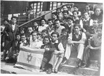 A group of teenagers poses of the steps of the Selvino children's home with an Israeli flag.
