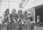 Four girls share a snack on the deck of the MS St.