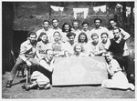 Group portrait of Jewish DP youth posing with a sign at a seminar of the Dror-Hehalutz Zionist youth movement in Czechoslovakia.