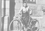 Frymka Russinek stands with her bicycle on the street after the war.