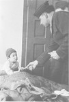 Rabbi Nathan Baruch visits a young child in bed in the Ulm displaced persons' camp.