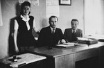 Three employees of the Stuttgart displaced persons camp welfare department pose in their office.
