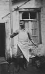 Hugo Pauly, a German-Jewish man wearing a large white apron, works in the family's butcher shop behind his home.