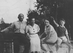 A Jewish family from Vilna sits on a railing while on an outing.