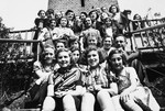 Group portrait of German-Jewish children sitting on the steps of the Ons Boschhious children's home in Driebergen.