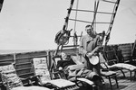 A female Jewish refugee relaxes on a deck chair while her husband stands next to her on the upper deck of the St.