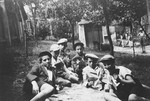 Boys in an Orthodox summer camp in Hungary play a game of cards on the lawn.