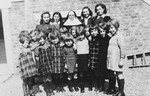 Two Jewish sisters pose with the nun who had hidden them and a group of Belgian children in the Couvent de la Misericorde in Louvain.
