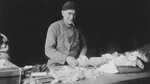 An elderly Jewish man sorts rags in a warehouse.  

Pictured is Simon de Zwarte, grandfather of the donor.