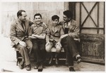 Two Jewish boys sit on a bench with their counselors at the Rothschild's Château Ferrière, where they are attending a summer camp sponsored by the OSE (Oeuvre de secours aux Enfants).