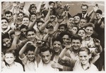Jewish DP youth who were members of the Buchenwald children's transport wave to the camera at the Ecouis children's home.