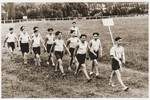 Jewish youth from the Le Vésinet children's home march down a grassy track during a sports meet.