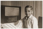 Rene Guttmann poses beside a large radio in the Mann family home in Kosice.