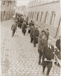 Under the supervision of American soldiers, German civilians carry wooden coffins containing the bodies of Hungarian, Russian and Polish Jews through Neunburg vorm Wald to the town cemetery for proper burial.