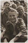 Jakub Finkelstajn sits among the members of the Buchenwald children's transport at an outdoor gathering on the grounds of the Ecouis children's home soon after their arrival.