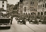Adolf Hitler salutes a motorized SA unit from his car during a Reichsparteitag (Reich Party Day) parade.