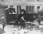 Civilians load Communist publications onto the back of a truck as police look on during a raid of the Karl-Liebknecht House (KPD headquarters), which was on the Buelowplatz in Berlin.