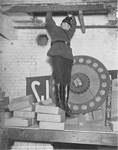 A member of the Schutzpolizei jumps down from a hole in the ceiling he searched during the closing of the Karl-Liebknecht House (KPD headquarters), which was on the Buelowplatz in Berlin.