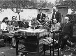 Members of the extended Baruch family pose outside around a table in the yard of their residence in Kyustendil, Bulgaria, following their expulsion from the capital, Sofia.