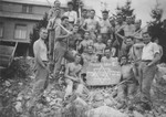 Jewish graduates of a military officers' school pose with a sign in a labor camp in the High Tatras.