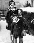 Three Jewish children pose outside in the snow in front of their grandparent's house in Kyustendil, Bulgaria.