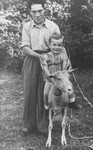 A Jewish DP living in the Heidenheim displaced persons camp, holds his son, who is riding on a goat.