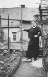 Else Trum (sister of Erna Gottschalk) poses for a photograph in a small garden.
