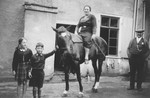 Erna Gottschalk poses on a horse.

Among those pictured are Gustav Gerson (right of Erna) and Alfred Gottschalk (left of Erna).