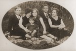 Members of the Gurfein and Saurhaft families pose outside in the grass in Dubiecko, Poland.