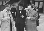 Norbert Wollheim (right) and Rabbi Leo Baeck (center) converse with an official soon after Baeck's arrival in Hamburg at the start of a three week visit to Germany.