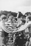 A Jewish child from Germany is passed along a line of children with clasped hands in a game at a Kinderlager [children's recreational summer camp] in Horserod, Denmark.