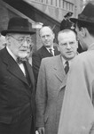 Rabbi Leo Baeck and Norbert Wollheim converse with an official soon after Baeck's arrival in Hamburg at the start of a three week visit to Germany.