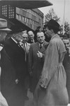 Norbert Wollheim (center, right) and Rabbi Leo Baeck (left) converse with an official soon after Baeck's arrival in Hamburg at the start of a three week visit to Germany.