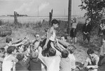 A Jewish child from Germany is passed around a circle in a trust game at a Kinderlager [children's recreational summer camp] in Horserod, Denmark.