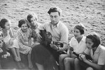 A group of Jewish girls from Germany sings along as one of their counselors play the guitar at a Kinderlager [children's recreational summer camp] in Horserod, Denmark.