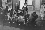 Jewish children from Germany who are on their way to a Kinderlager [children's recreational summer camp] in Horserod, Denmark, wait to board a train in the waiting room of the train station.