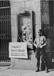 An SA picket stands in front of the Jewish-owned Tietz department store wearing a boycott sign that reads:  "Germans defend yourselves; don't buy from Jews!"