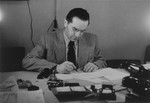 Chief medical officer, Dr. Naum Wortman, at his desk in the Ebelsberg displaced persons camp.