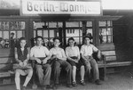 Five young DPs await a train at the Berlin-Wannsee train station.