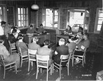 Civilian and military administrative staff of an unidentified DP camp in Austria gather for a daily meeting.