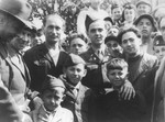 U.S. Army chaplain Rabbi Mayer Abramowitz poses with a group of adults and children at a summer camp for Jewish DP children in the Grunewald Forest.